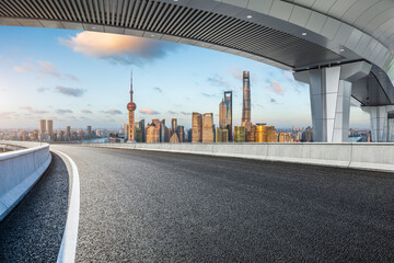 Asphalt highway and city skyline with modern buildings in Shanghai at sunset, China.