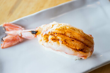 Burnt sweet shrimp topped with spicy sauce and creamy salad nigiri sushi. Selective focus.