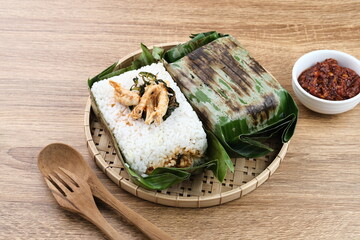 Nasi Bakar, rice with spices wrapped in banana leaves with spicy shredded chicken and basil leaves and then grilled. Selected focus
