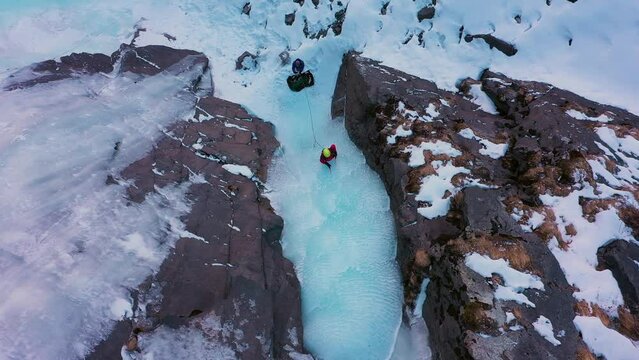 Ice Climbing on Frozen Waterfall, Aerial Top-Down View. Barskoon Valley, Kyrgyzstan. Drone Flies Sideways