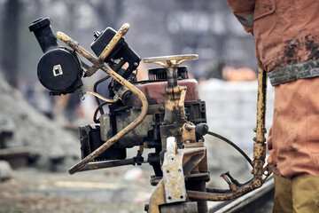 Construction worker using machine for steel train tracks.