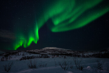 Northern lights over a snowcovered mountain in Norway