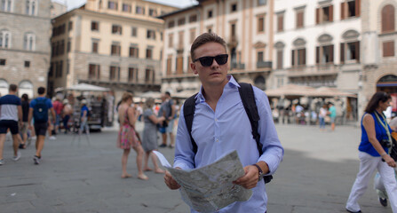 Young man in an old european city with a map