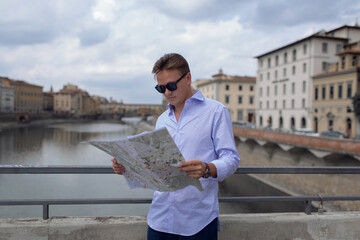 Young man in an old european city with a map