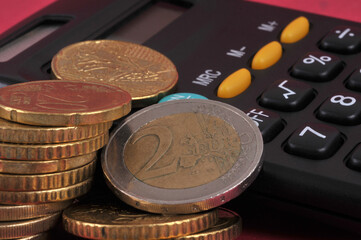 Concept de budget avec de pièces de monnaie en euro sur une calculatrice en gros plan