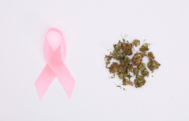 cancer awareness pink ribbon with marijuana buds in amount, white background