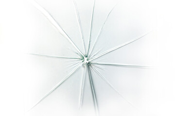 The hole in the broken and cracked glass on white background, closeup