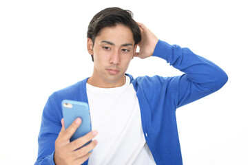 スマートフォンを持って悩む男性