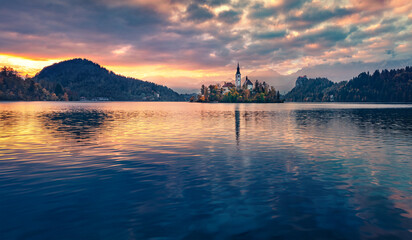 Dranatic morning view of Pilgrimage Church of the Assumption of Maria. Great autumn sunrise on Bled...