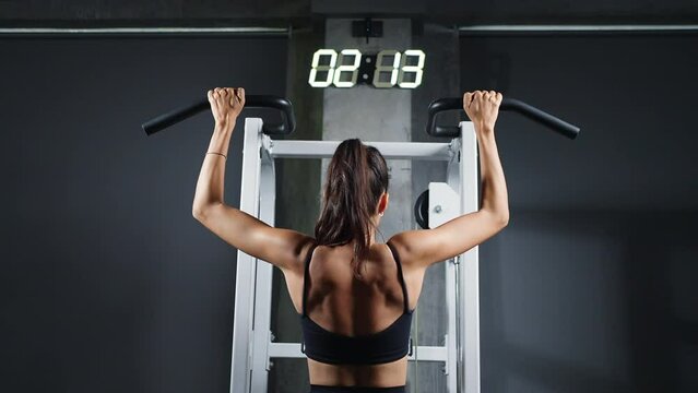 Hispanic woman athletic workout exercise pulling up body weight lifting machine at fitness club. Female bodybuilder do body building muscle weight training at sport gym. Health care motivation concept