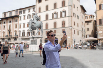 Fototapeta premium Young handsome guy tourist on the square in Europe