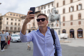 Young handsome guy tourist on the square in Europe