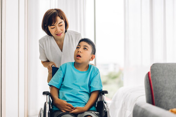 Portrait of enjoy happy love family asian mother playing and carer helping look at disabled son child sitting in wheelchair moments good time at home.disability care concept