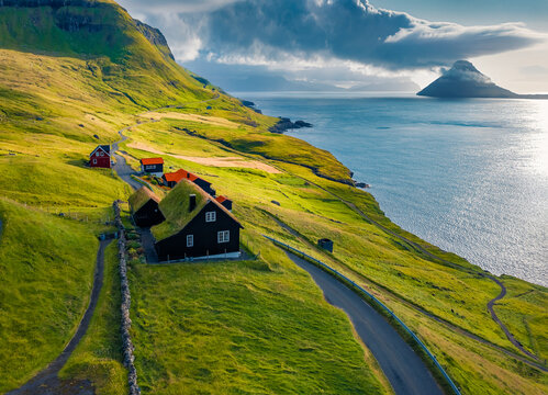 Majestic summer view from flying drone of Velbastadur village with typical turf-top houses. Extraordinary morning scene of Streymoy island, Faroe, Denmark, Europe. Traveling concept background..