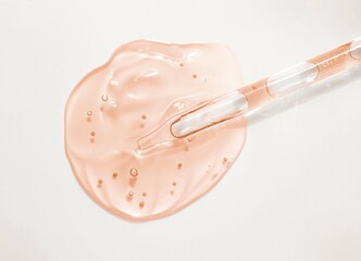 Liquid yellow orange gel or serum with dropper on gray background