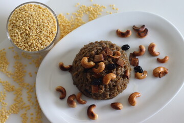 Sweet Pongal. An Indian sweet dish made of white rice and yellow moong lentils and jaggery. Garnished with ghee fried cashews nuts and coconut bits
