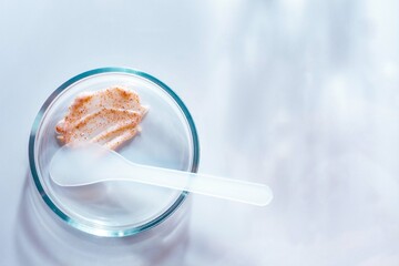 Fototapeta na wymiar Cosmetic peeling scrub smudge textured on petri dish background