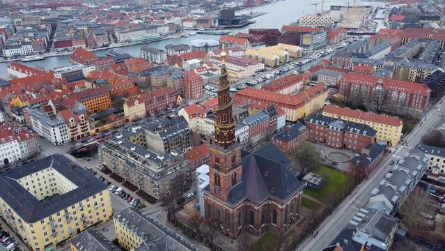 Aerial drone footage of the Christiana district and the Vor Frelsers church with its famous bellt tower in Copenhagen in winter in Denmark capital city