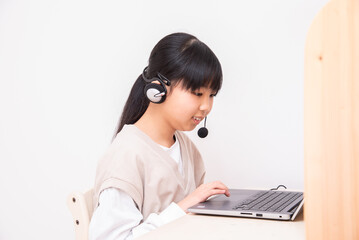 子供部屋でオンライン授業で勉強するアジア人の女の子