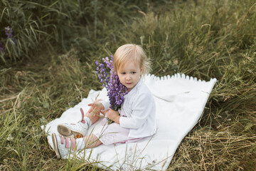girl sitting on a blanket in a field of flowers