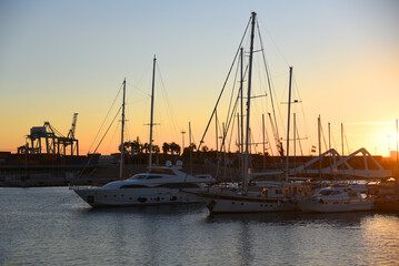 Yachts and motor boats in La Marina de Valencia, Spain. Luxury yacht and fishing motorboat in yacht club at Mediterranean Sea. Skiff and Sailboat in port. Yachting and sailing sport. Quai at ​Dock.