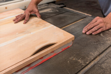 Trimming a piece of plywood intro exact measurements with a cabinet table saw. At a furniture...