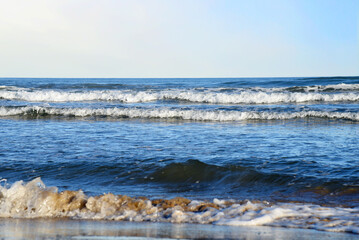 Waves at sea. Waves at sea during storm and wind. Wave from the sea goes on land to the beach. Splashing Waves in ocean, background, texture. Wave at Rising Storm.