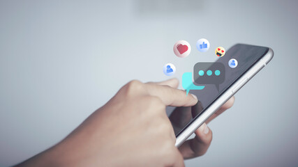 Live Chat on Communication social network Concept. Person hand using smartphone typing, playing social media chatting conversation in chat box icons pop up.