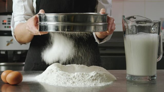 The cook sifts the flour through a sieve