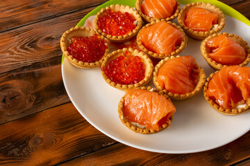 Obraz na płótnie Canvas edible baskets with red caviar and pieces of salmon.