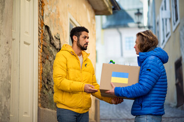 Volunteers collecting boxes with Humanitarian aid for Ukrainian refugees in street