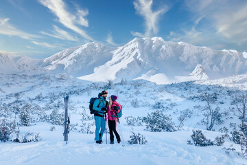 Naklejka na ściany i meble Ski touring couple taking break on the top of mountain in the Low Tatras in Slovakia.