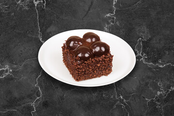 Delicious chocolate cake on black marble table, close-up