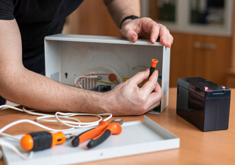 a man repairs a power supply for charging batteries