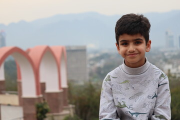 portrait of a young Pakistani boy sitting on view point Islamabad  © Shafique