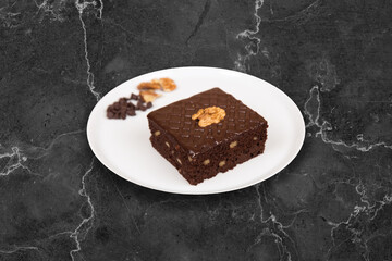 Slice of homemade brownie on plate on table