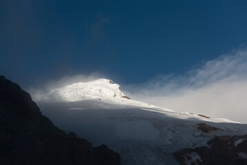 Peak and glacier of the Cayambe volcano at sunset with mist, Cayambe Coca national park, Ecuador.