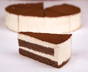 Tiramisu cake with cocoa decoration on a plate. white background.