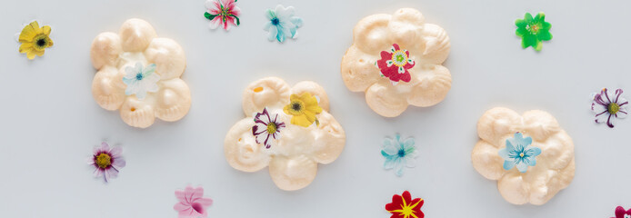 Top down view of a homemade meringues topped with edible flowers.