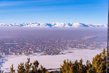 Ski slopes and Ski lifts. Small pine trees with snow. Mountain skiing and snowboarding. View of...