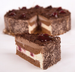 3 chocolate cakes with fresh strawberries. It is served on a white plate on a black background.