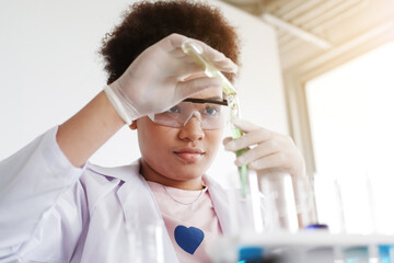 Smiling African black girl student is study and test for chemical and science. She is experimenting...
