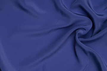 Silk texture luxurious satin for abstract background. Fabric of blue tone.