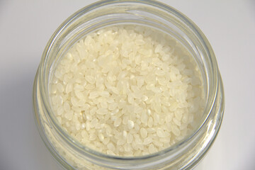 White rice in a jar. On a white background.