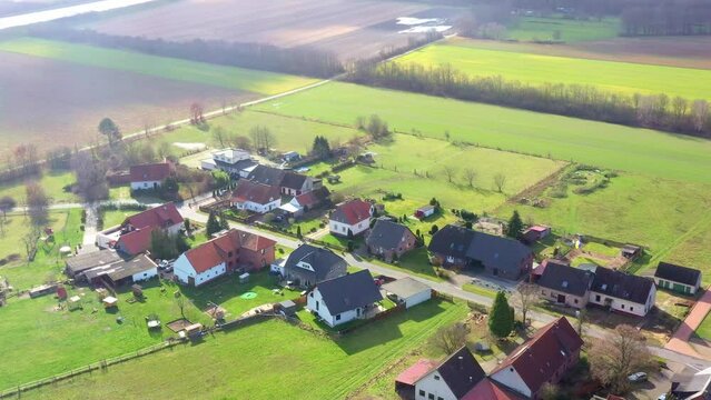 Aerial view of a village street near Gifhorn, Germany, with family houses surrounded by green meadows and fields