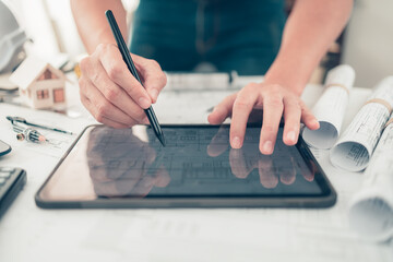 Architect engineer use tablet read and check drawing design working on blueprint. House planning...