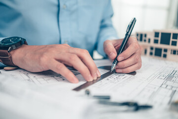 Architect engineer use pen and  angle protector drawing design working on blueprint. House planning...