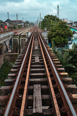 Fototapeta na wymiar Train tracks in suburban areas on a cloudy day in Indonesia