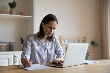 Business woman sit at table holds pen make correction in document, check written data, do paperwork...
