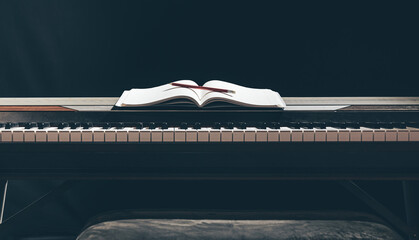 Open notepad on piano keys in the dark, copy space. © puhimec